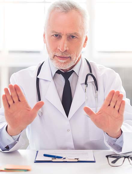 male doctor shows a gesture with his hands and looks at the camera