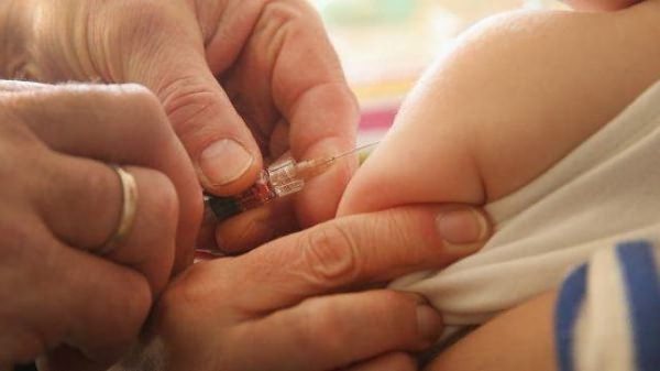 Injection in the arm of a newborn at one year of age to prevent measles